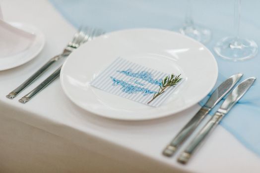 the presidium of the newlyweds in the banquet hall of the restaurant is decorated with candles and green plants, the general tone of the hall is beige