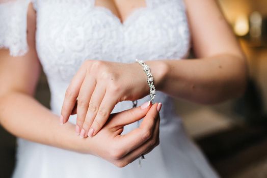 the bride wears a bracelet with transparent stones on her hand