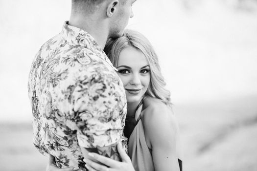 blonde girl in a light blue dress and a guy in a light shorts and short shert in a granite quarry