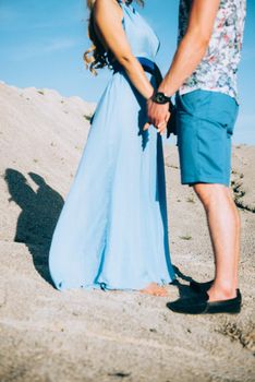 blonde girl in a light blue dress and a guy in a light shorts and short shert in a granite quarry