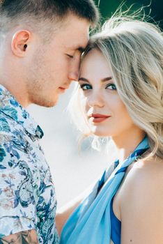 blonde girl in a light blue dress and a guy in a light shorts and short shert in a granite quarry