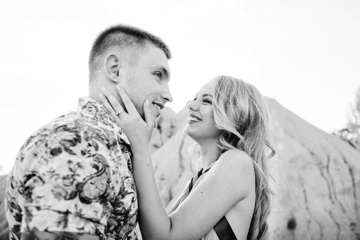 blonde girl in a light blue dress and a guy in a light shorts and short shert in a granite quarry