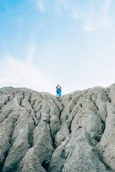 blonde girl in a light blue dress and a guy in a light shorts and short shert in a granite quarry