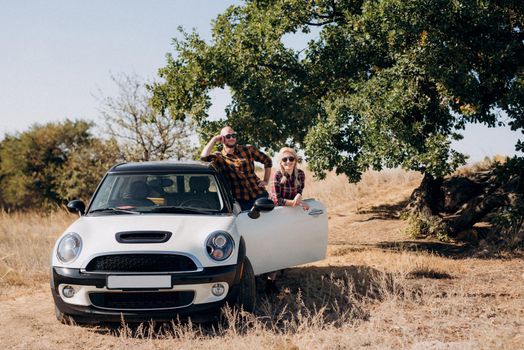 traveling by car of a young couple of a guy and a girl in plaid shirts