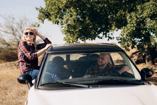 traveling by car of a young couple of a guy and a girl in plaid shirts