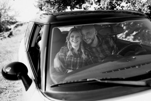 traveling by car of a young couple of a guy and a girl in plaid shirts