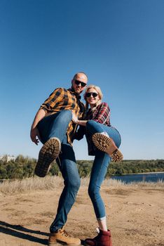 Guy and girl in caged shirts and trekking shoes on granite rocks