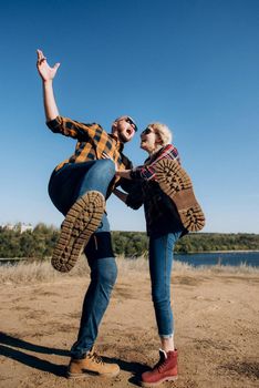 Guy and girl in caged shirts and trekking shoes on granite rocks