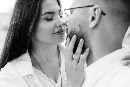 young couple in love a guy with a beard and a girl with dark hair in light clothes in the green forest