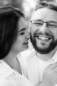 young couple in love a guy with a beard and a girl with dark hair in light clothes in the green forest