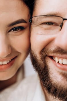 young couple in love a guy with a beard and a girl with dark hair in light clothes in the green forest