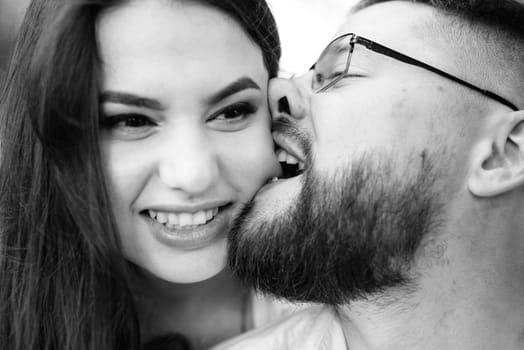 young couple in love a guy with a beard and a girl with dark hair in light clothes in the green forest