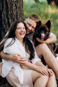 Big dog for a walk with a guy and a girl on the green prairie