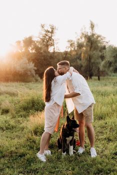 Big dog for a walk with a guy and a girl on the green prairie