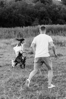 Big dog for a walk with a guy and a girl on the green prairie