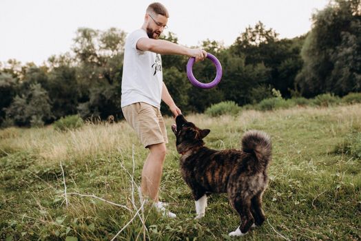 Big dog for a walk with a guy and a girl on the green prairie