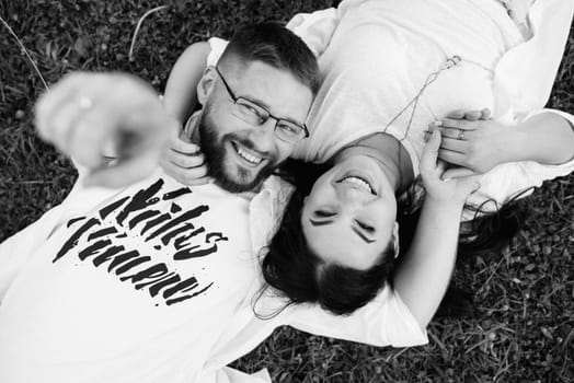 young couple in love a guy with a beard and a girl with dark hair in light clothes in the green forest