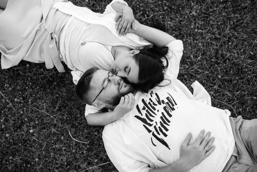 young couple in love a guy with a beard and a girl with dark hair in light clothes in the green forest