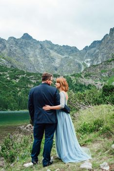 young couple on a walk near the lake surrounded by the Carpathian mountains