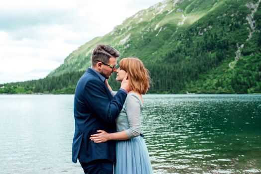 young couple on a walk near the lake surrounded by the Carpathian mountains