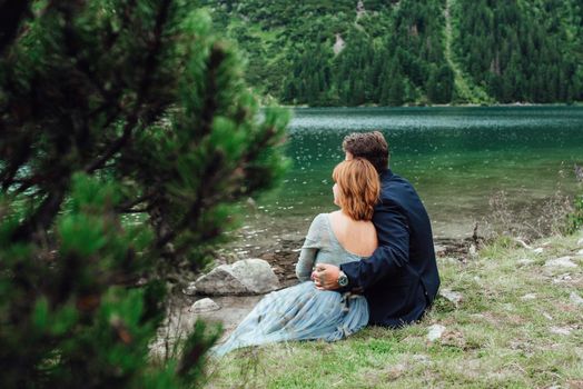 young couple on a walk near the lake surrounded by the Carpathian mountains