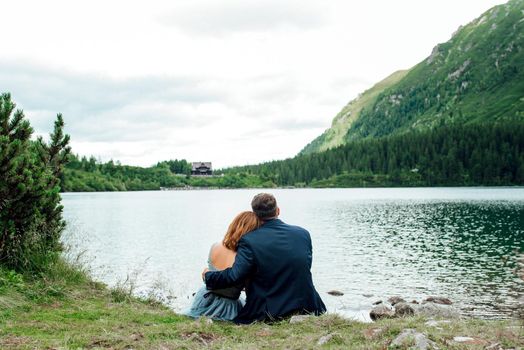 young couple on a walk near the lake surrounded by the Carpathian mountains