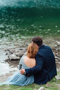 young couple on a walk near the lake surrounded by the Carpathian mountains