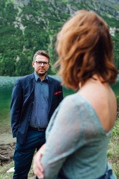 young couple on a walk near the lake surrounded by the Carpathian mountains