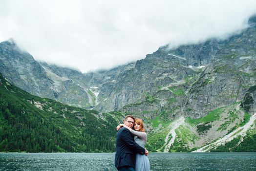 young couple on a walk near the lake surrounded by the Carpathian mountains