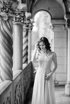 A girl in a light pink dress against the background of a medieval Polish stone castle