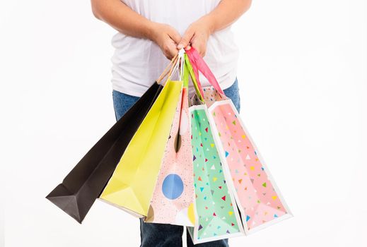 Happy woman hand holding shopping bags multicolor, young female hold many packets within arms isolated on white background, Black friday sale concept