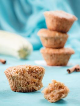 Close up view of muffin with zucchini, carrots, apple and cinnamon on blue concrete background. Sweet vegetables homemade muffins. Toddler-friendly recipe idea. Copy space. Shallow DOF