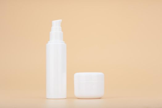 Minimalistic still life with set of face cream and under eye cream against beige background. Concept of beauty products for daily skin care. High quality photo