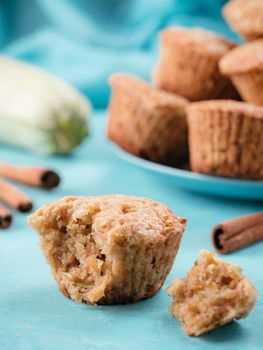 Close up view of muffin with zucchini, carrots, apple and cinnamon on blue concrete background. Sweet vegetables homemade muffins. Toddler-friendly recipe idea. Copy space. Shallow DOF