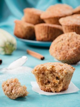 Close up view of muffin with zucchini, carrots, apple and cinnamon on blue concrete background. Sweet vegetables homemade muffins. Toddler-friendly recipe idea. Copy space. Shallow DOF