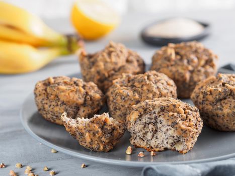 Close-up view of healthy gluten-free homemmade banana muffins with buckwheat flour. Vegan muffins with poppy seeds on gray plate over gray wooden table