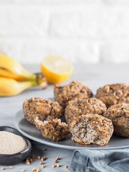 Close-up view of healthy gluten-free homemmade banana muffins with buckwheat flour. Vegan muffins with poppy seeds on gray plate over gray wooden table. Copy space