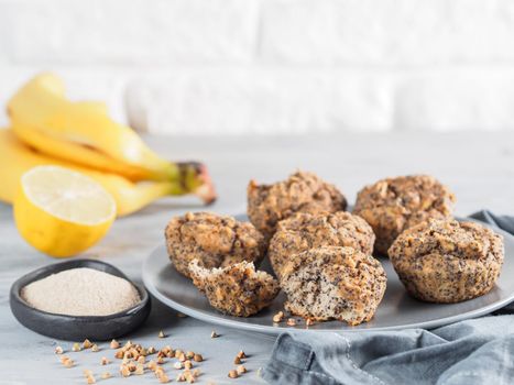 Close-up view of healthy gluten-free homemmade banana muffins with buckwheat flour. Vegan muffins with poppy seeds on gray plate over gray wooden table. Copy space