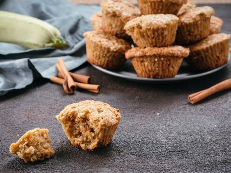 Close up view of muffin with zucchini, carrots, apple and cinnamon on black cement background. Sweet vegetables homemade muffins. Toddler-friendly recipe idea. Copy space. Shallow DOF