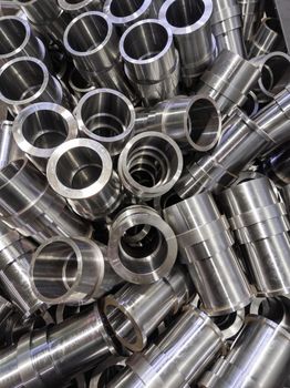 abstract industrial shiny steel production background with cnc machined pipes - selective focus and lens blur technique.