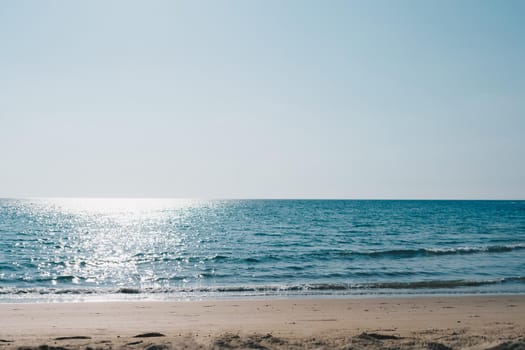 Tropical nature clean beach and white sand in summer season with sun light blue sky background.