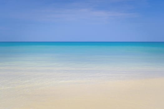 Tropical nature clean beach and white sand in summer season with sun light blue sky background.