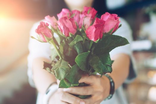 Woman happy hold pink roses recieve from someone in love on Valentine's day.   