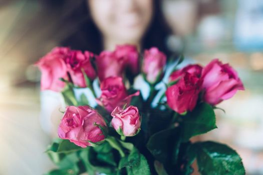 Woman happy hold pink roses recieve from someone in love on Valentine's day.   