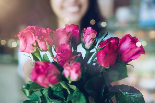 Woman happy hold pink roses recieve from someone in love on Valentine's day.   