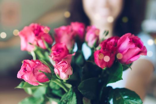 Woman happy hold pink roses recieve from someone in love on Valentine's day.   