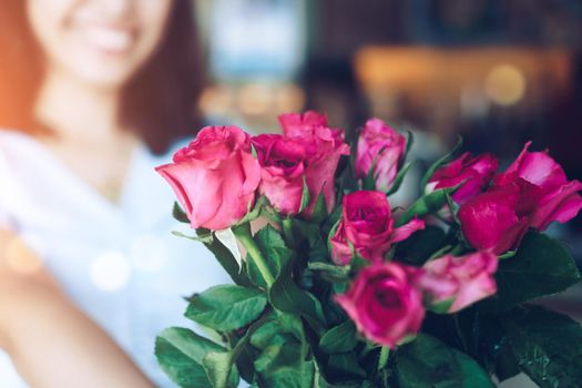 Woman happy hold pink roses recieve from someone in love on Valentine's day.   