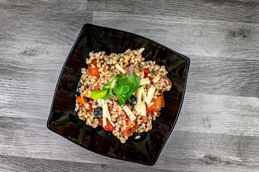 served on black plate of farroset salad on wooden table