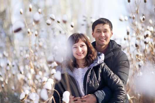 Winter portrait of a young interracial couple as they hug each other.