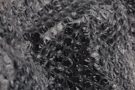 crumpled dark air bubble wrap - real life close-up background with selective focus